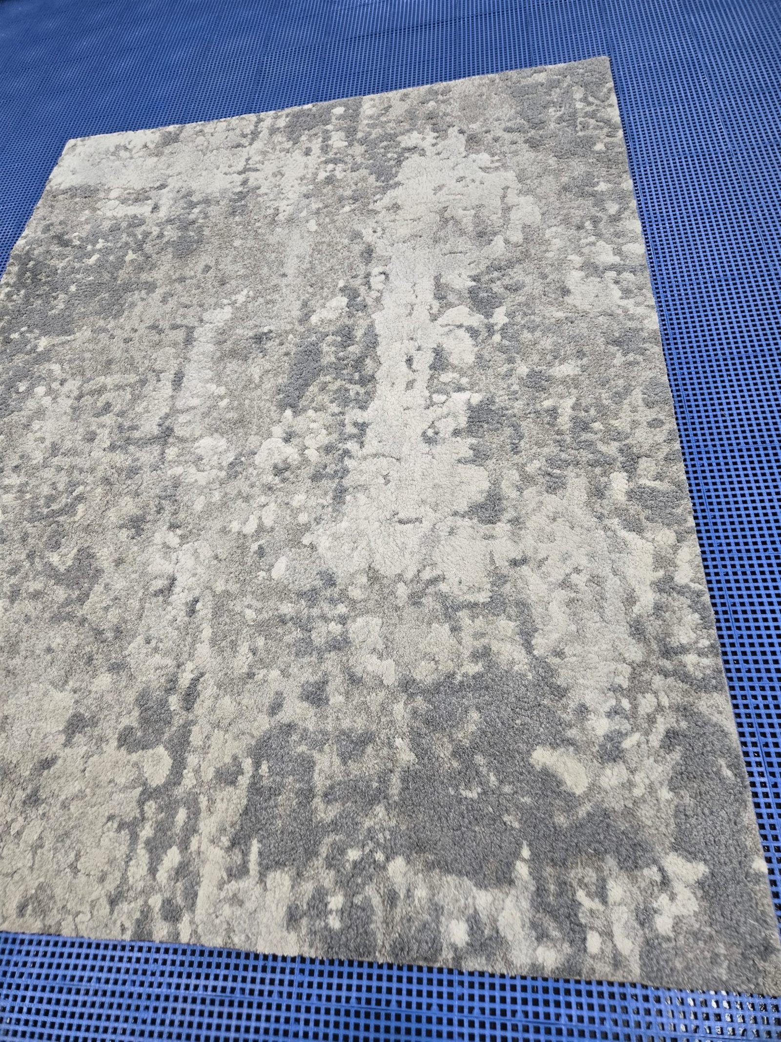 Clean area rug laid flat on the wash floor after a full immersion wash at Dallas Rug Cleaning