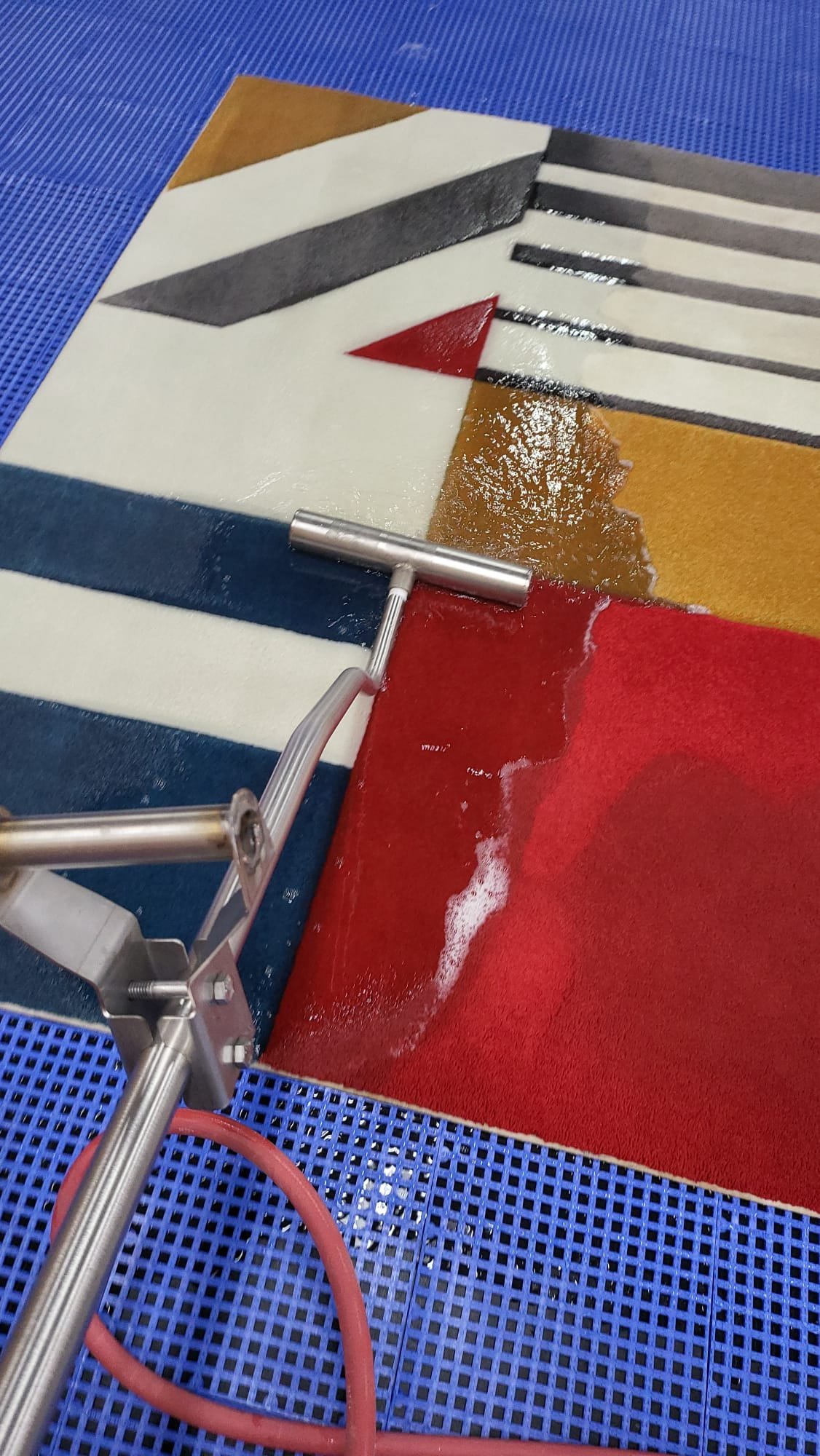 Technician hand-washing an area rug at a dedicated rug-cleaning facility